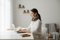 Portable smart cervical neck massager worn by a professional in a minimalist home office setting